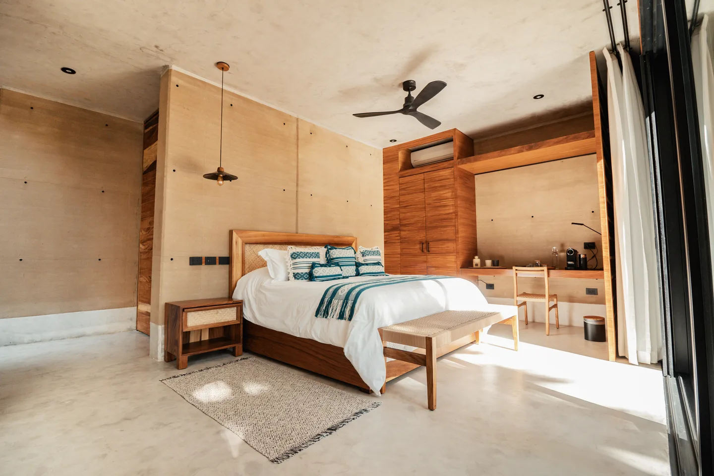 Terra Room with a king bed, rammed-earth walls, built-in timber desk and sliding glass to the terrace at NEST Los Cabos